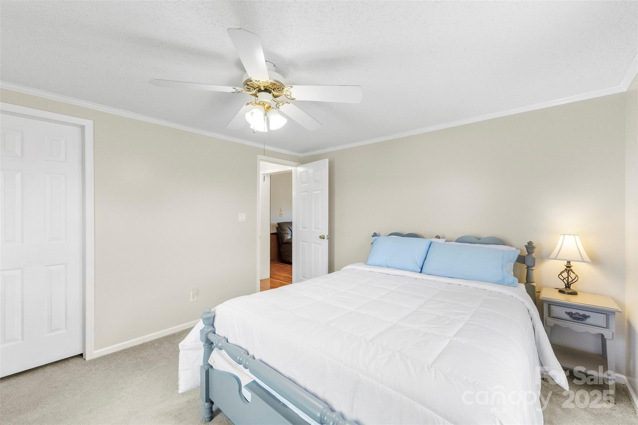 320 Huffstetler Lake Road Dallas, NC 28034 - Photo 24 of 47 a bedroom with a bed and a chandelier