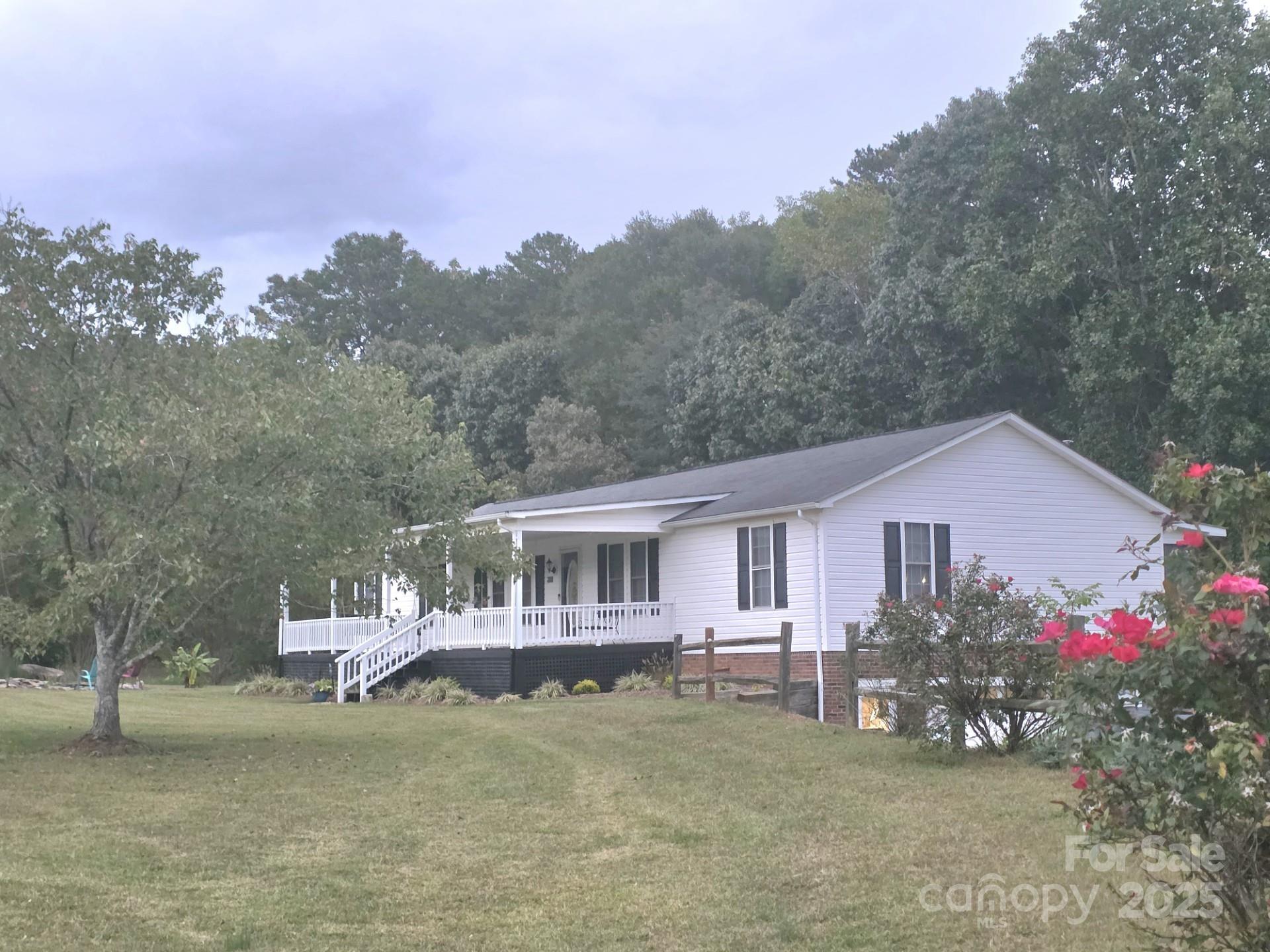 320 Huffstetler Lake Road Dallas, NC 28034 - Photo 3 of 47 a front view of a house with a garden and a yard