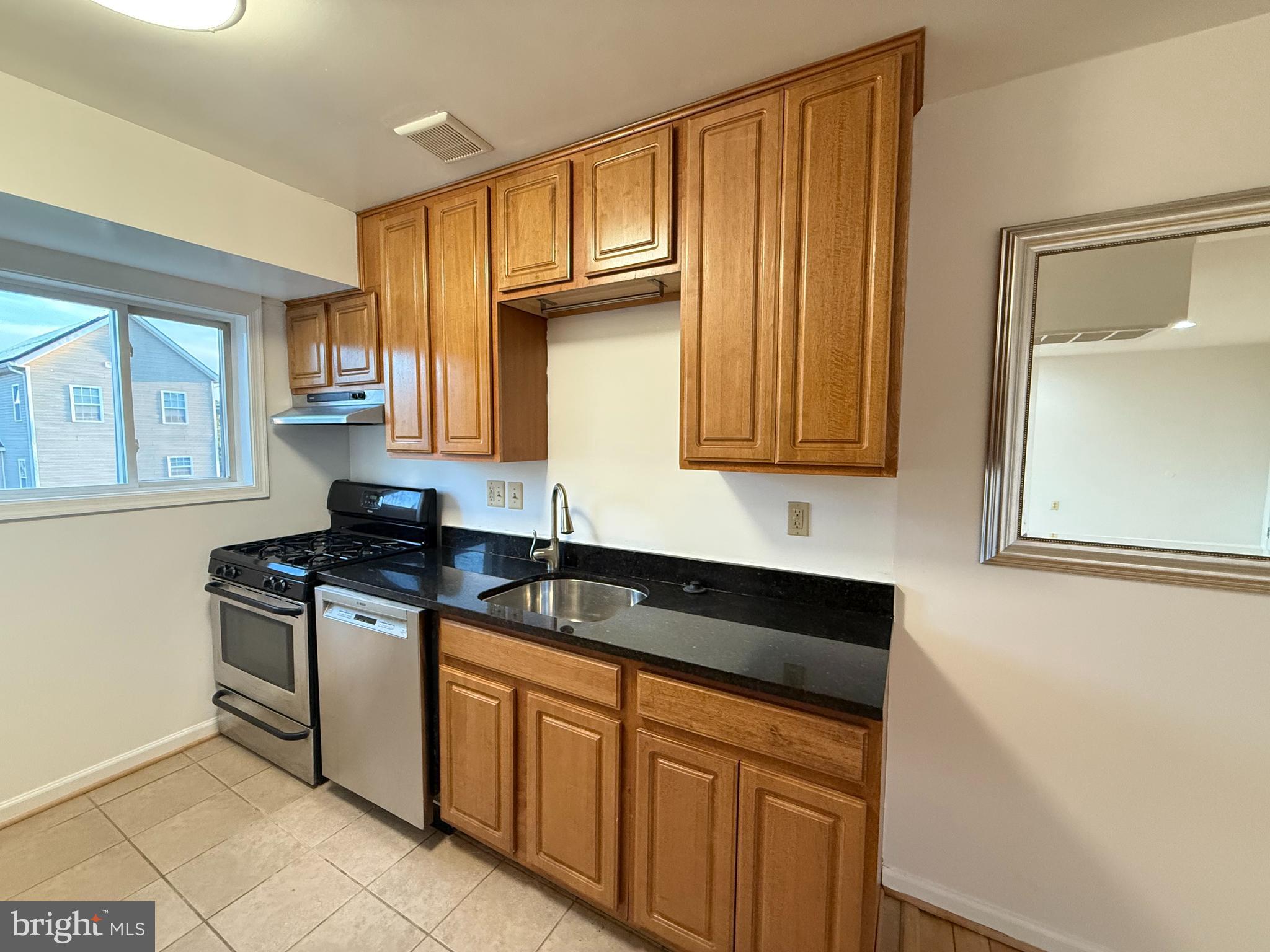 5009 D Street Southeast, Unit 303 Washington, DC 20019 - Photo 13 of 25 a kitchen with stainless steel appliances granite countertop a sink stove and cabinets