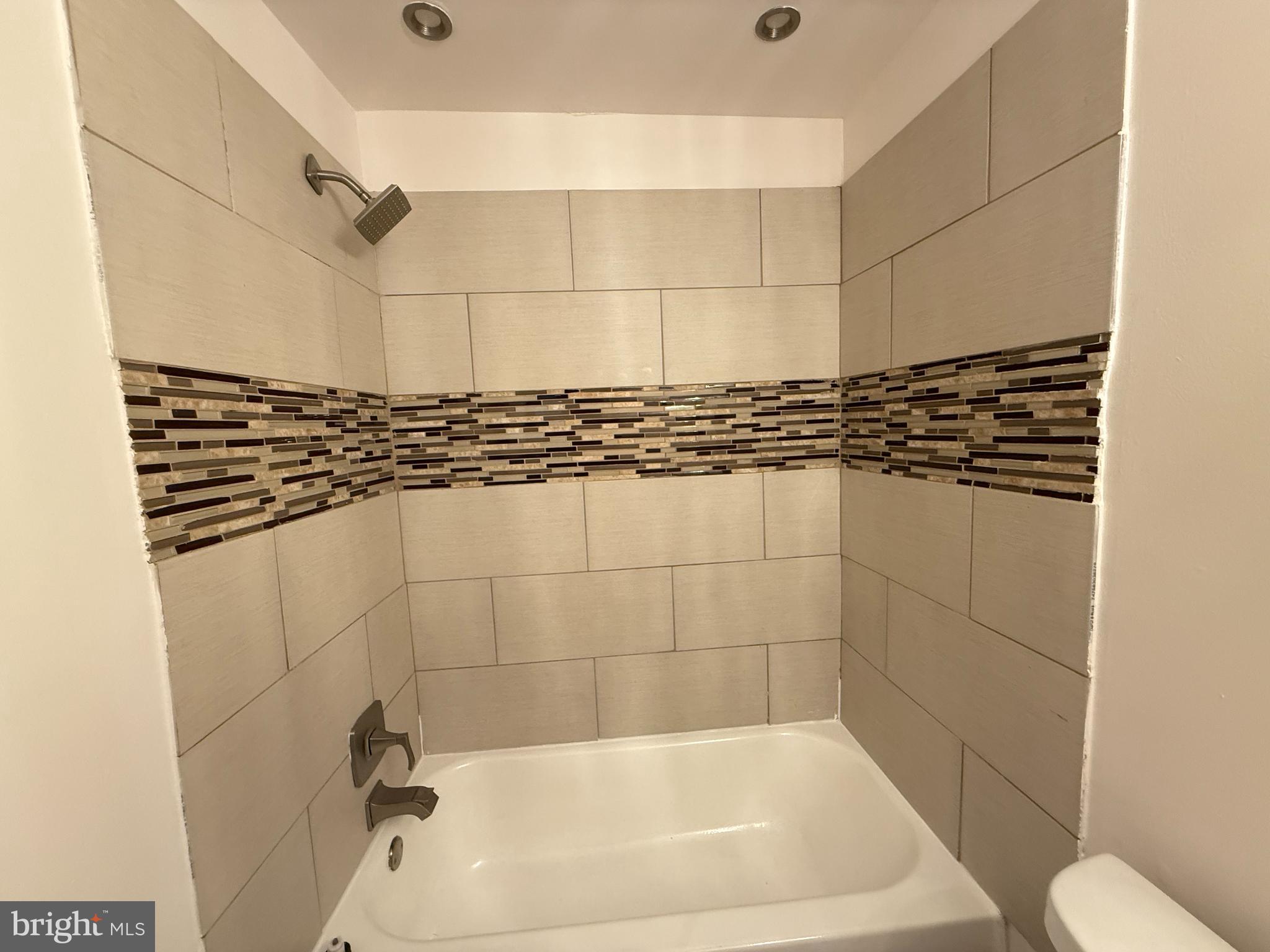 5009 D Street Southeast, Unit 303 Washington, DC 20019 - Photo 15 of 25 a bathroom with a bathtub and shower