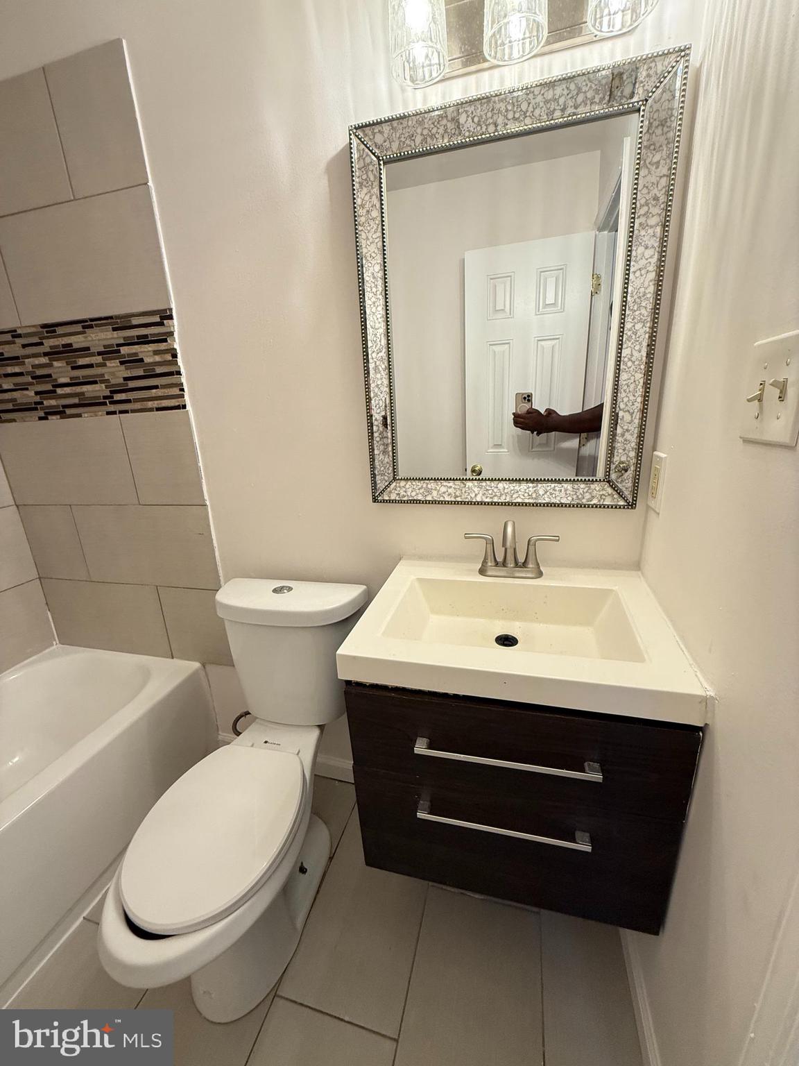5009 D Street Southeast, Unit 303 Washington, DC 20019 - Photo 16 of 25 a bathroom with a toilet a sink and a mirror