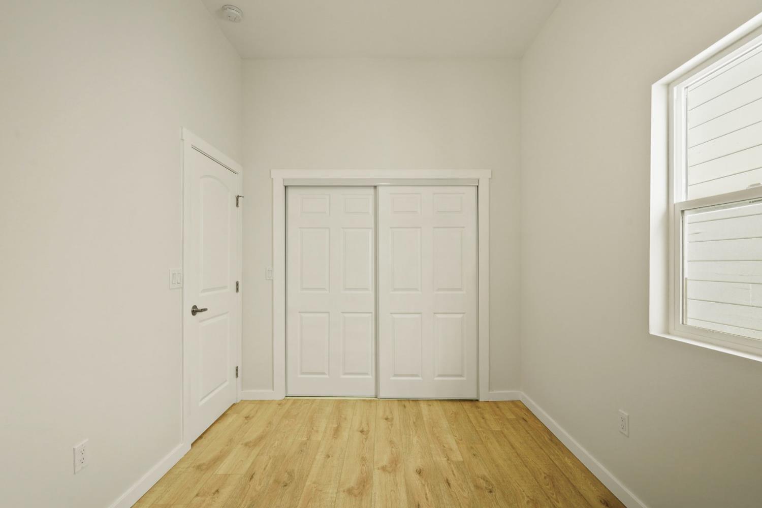 1269 B Street Walnut Grove, CA 95690 - Photo 22 of 42 a view of an empty room with wooden floor and a window