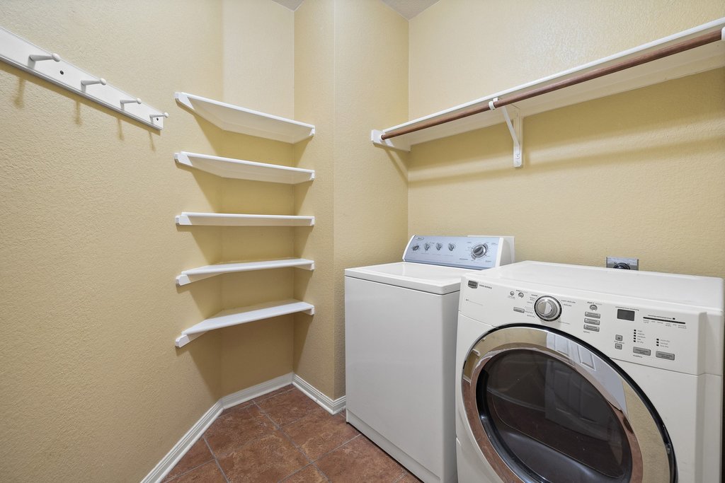 347 Spring Drive Kyle, TX 78640 - Photo 36 of 40 A well-organized laundry room features built-in shelving and convenient hanging space.