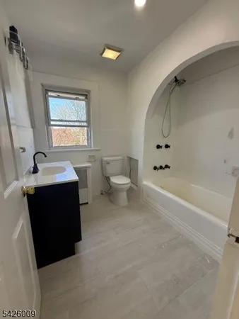 a spacious bathroom with a bathtub sink and mirror