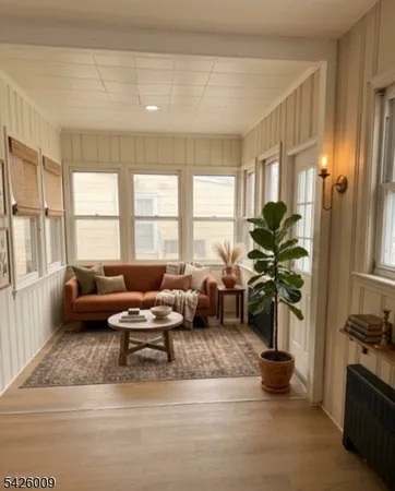 a living room with furniture floor to ceiling window and a flat screen tv