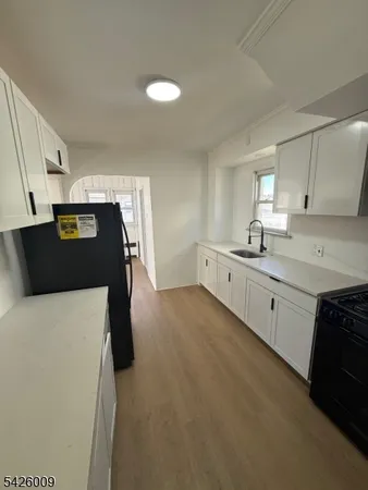 a kitchen with stainless steel appliances a sink a stove top oven a counter space and cabinets
