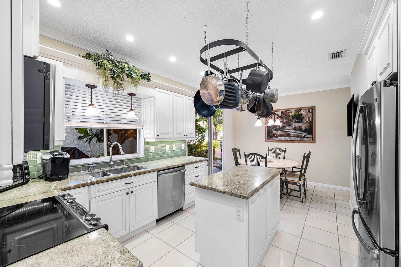 7155 Via Palomar Boca Raton, FL 33433 - Photo 11 of 45 a kitchen with a sink dishwasher a stove a refrigerator and cabinets