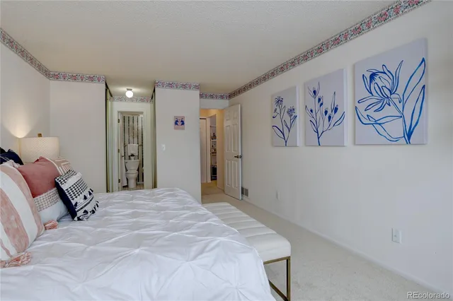 a bedroom with a large bed and painting on the wall