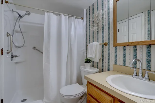 a bathroom with a granite countertop sink toilet and shower