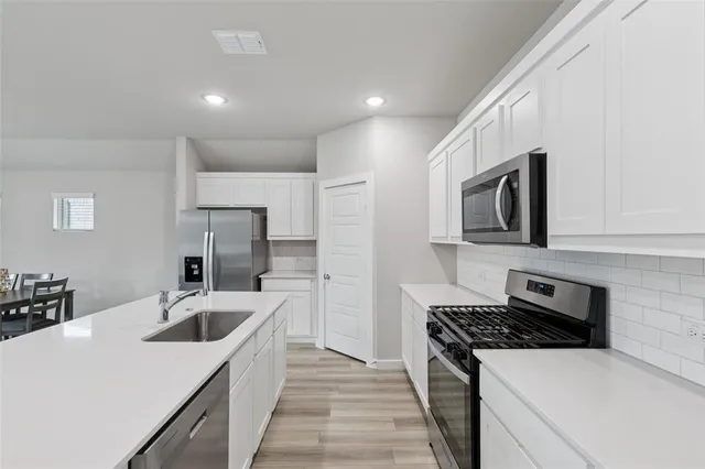 a kitchen with a sink stove and refrigerator