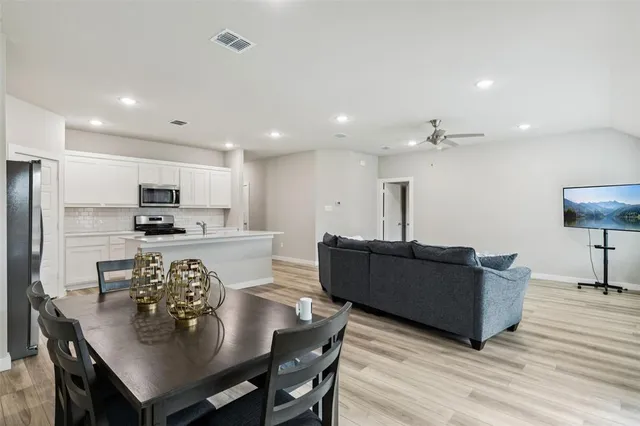 a kitchen with a table chairs refrigerator and microwave