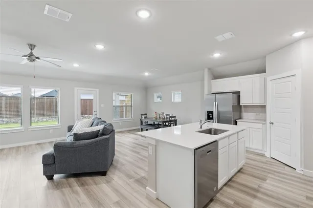a view of kitchen island a sink and living room with couches
