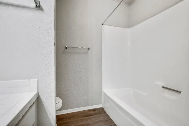 a bathroom with a granite countertop bathtub and toilet