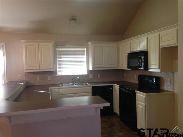 213 Cass Circle Tyler, TX 75703 - Photo 5 of 44 a kitchen that has a sink and a stove top oven