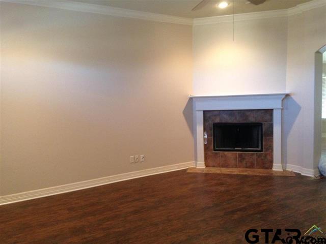 213 Cass Circle Tyler, TX 75703 - Photo 7 of 44 an empty room with wooden floor and fireplace