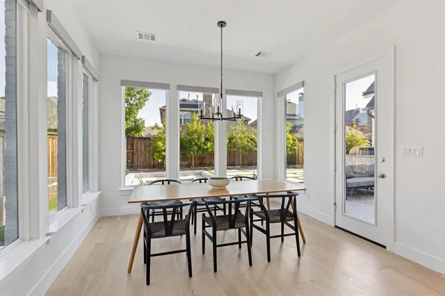 a dining room with furniture large windows and wooden floor