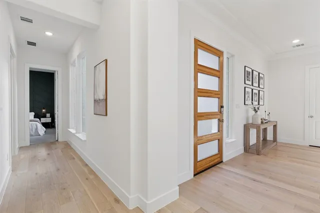 a view of a hallway with wooden floor and furniture