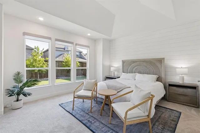 a bedroom with a bed and large windows