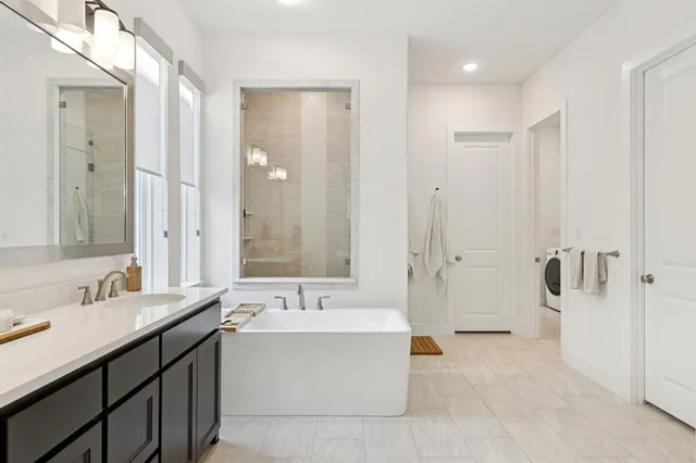 a spacious bathroom with a bathtub shower sink double and mirror