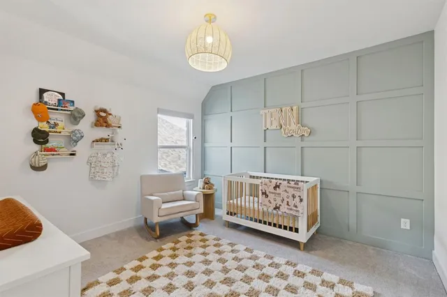 a living room with a baby crib furniture and a chandelier