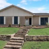 a front view of a house with a yard and outdoor seating