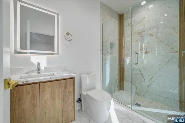 a bathroom with a granite countertop sink toilet and shower
