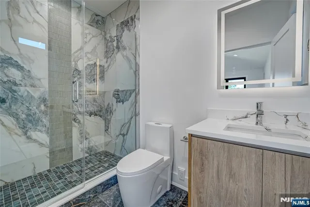 a bathroom with a granite countertop sink toilet and shower
