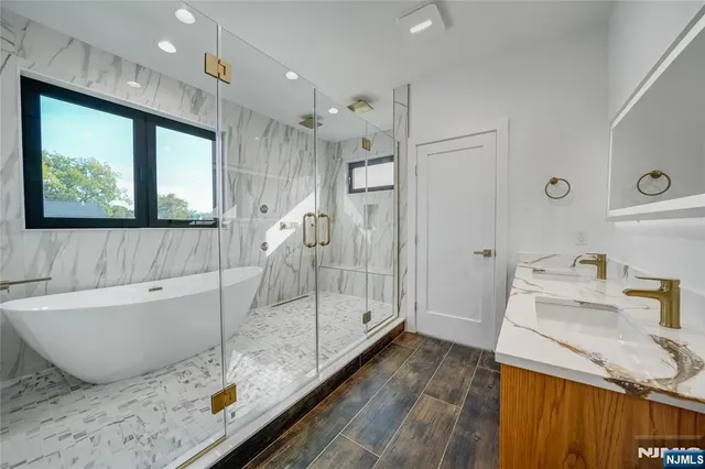 a bathroom with a granite countertop sink a toilet and bathtub