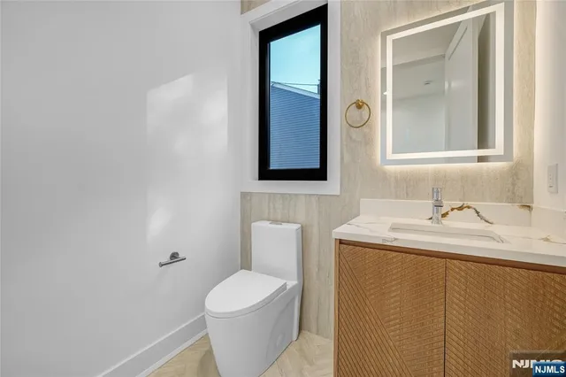 a bathroom with a toilet sink and mirror