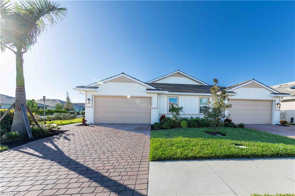 882 Enbrook Loop Naples, FL 34114 - Photo 2 of 19 a front view of a house with a yard and potted plants