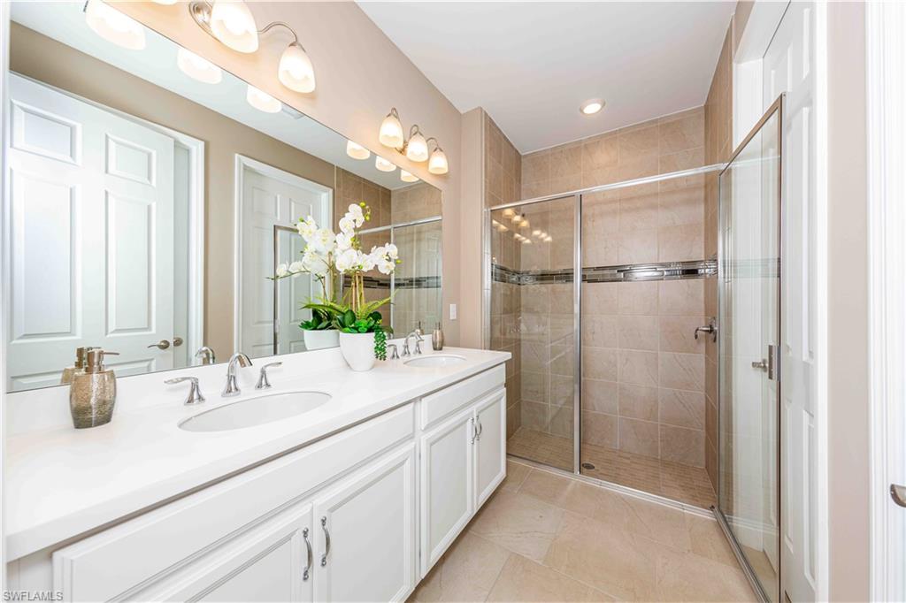 882 Enbrook Loop Naples, FL 34114 - Photo 9 of 19 a bathroom with a double vanity sink mirror and shower