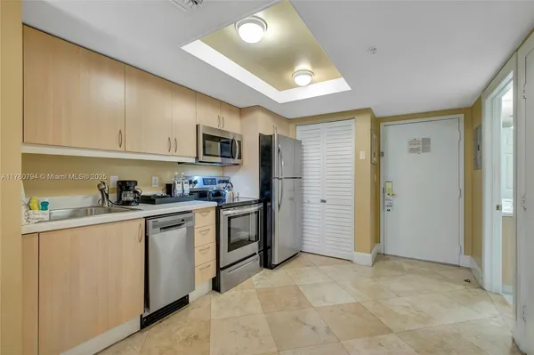 a kitchen with stainless steel appliances granite countertop a refrigerator and a stove top oven