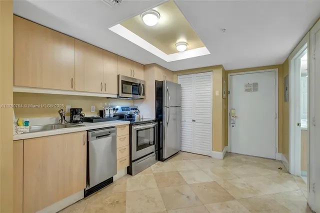 a kitchen with stainless steel appliances granite countertop a refrigerator and a stove top oven