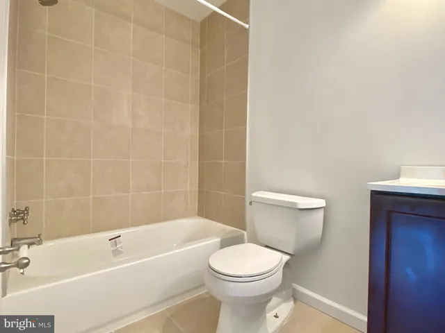 a white toilet and tub sitting next to a bathroom sink