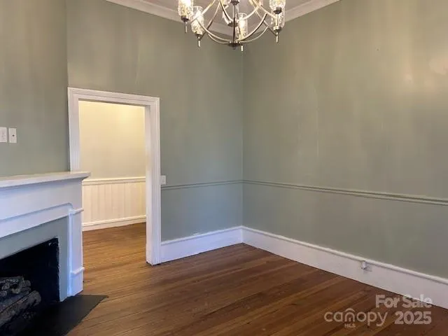 a view of empty room with wooden floor and fireplace