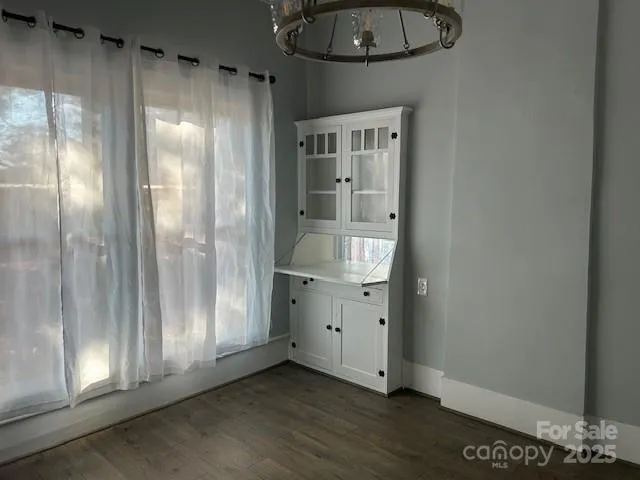 an empty room with wooden floor and cabinet