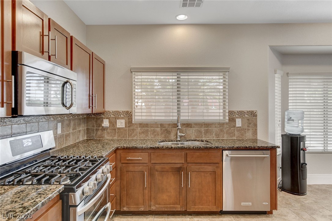 191 Verde Ridge Court Henderson, NV 89012 - Photo 16 of 36 Kitchen with appliances with stainless steel finishes, a sink, dark stone countertops, and recessed lighting