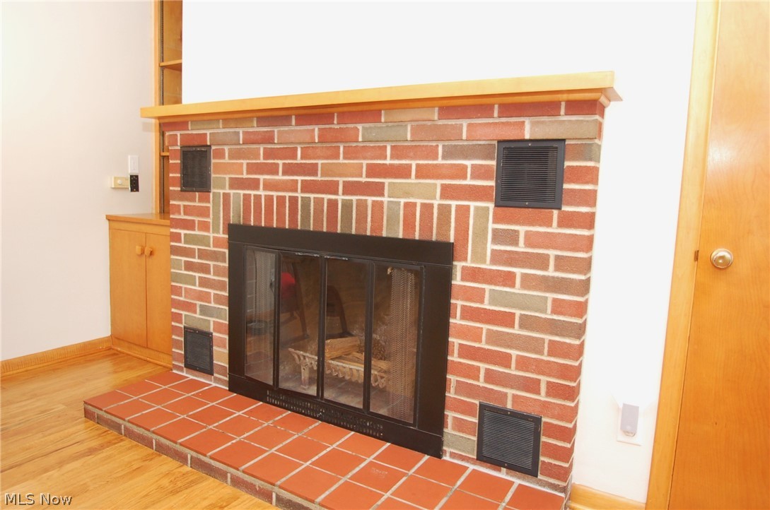 1299 State Road Vermilion, OH 44089 - Photo 6 of 36 Interior details featuring a brick fireplace and hardwood / wood flooring