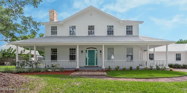 a front view of a house with a garden and plants