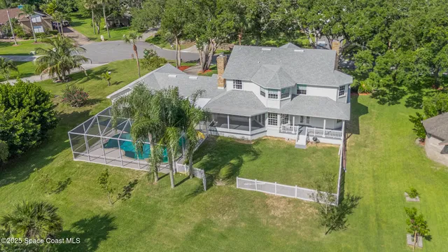 a view of a swimming pool with lawn chairs and a yard