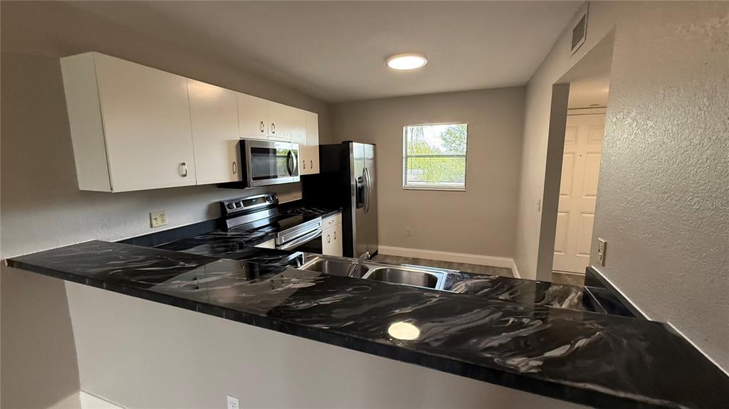 175 Kings Highway, Unit 1126 Punta Gorda, FL 33983 - Photo 4 of 17 a kitchen with a sink stove and microwave
