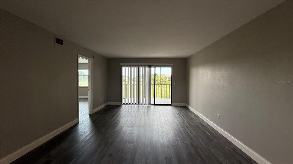 175 Kings Highway, Unit 1126 Punta Gorda, FL 33983 - Photo 5 of 17 an empty room with wooden floor and windows