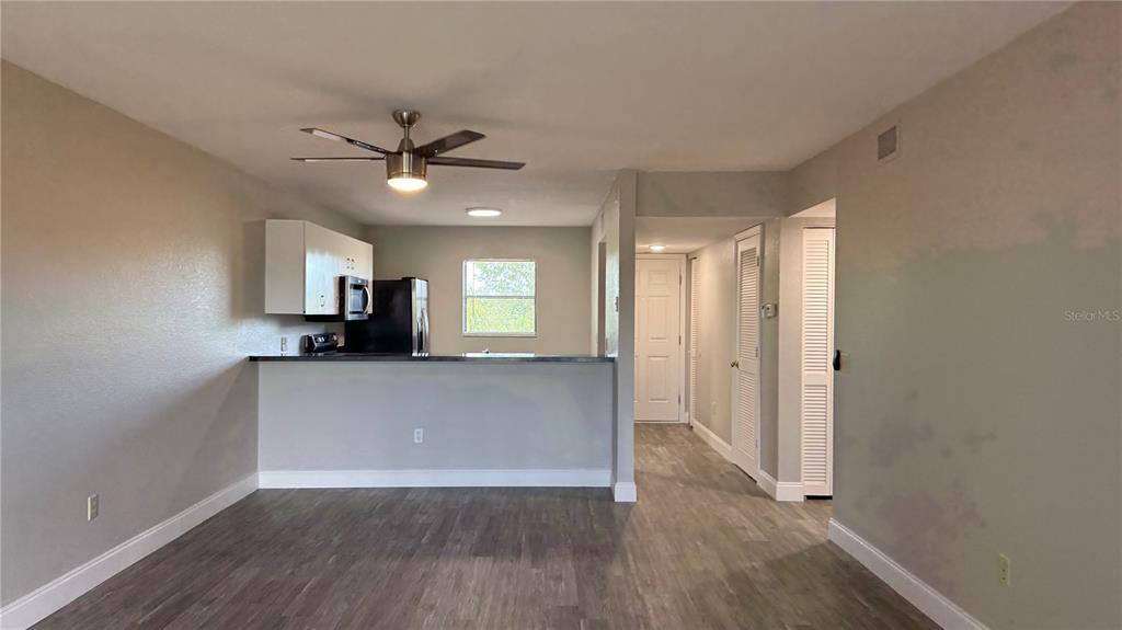 175 Kings Highway, Unit 1126 Punta Gorda, FL 33983 - Photo 7 of 17 a living room with stainless steel appliances a wooden floor a window and a kitchen view