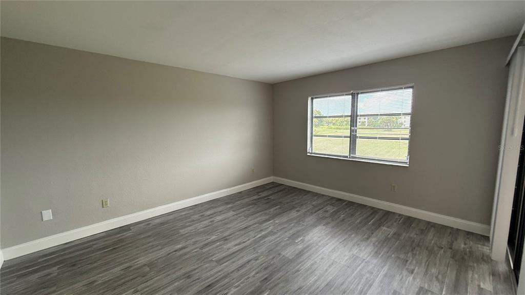175 Kings Highway, Unit 1126 Punta Gorda, FL 33983 - Photo 8 of 17 an empty room with wooden floor and windows