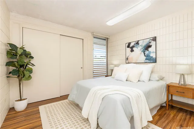 a bedroom with a bed and a potted plant