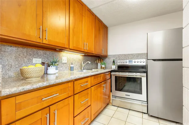 a kitchen with granite countertop stainless steel appliances a stove a sink and a microwave