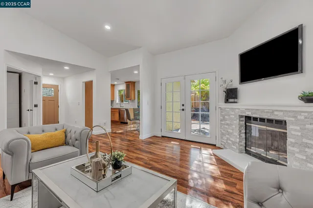 a living room with furniture a flat screen tv and a fireplace