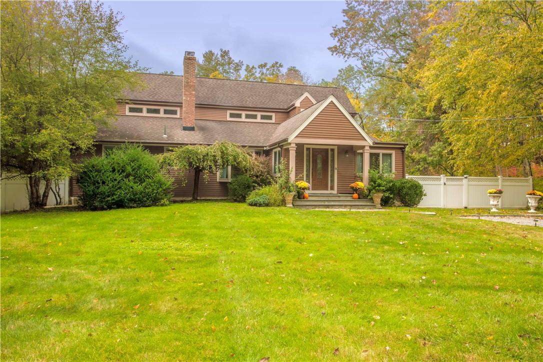 a front view of a house with a yard and trees