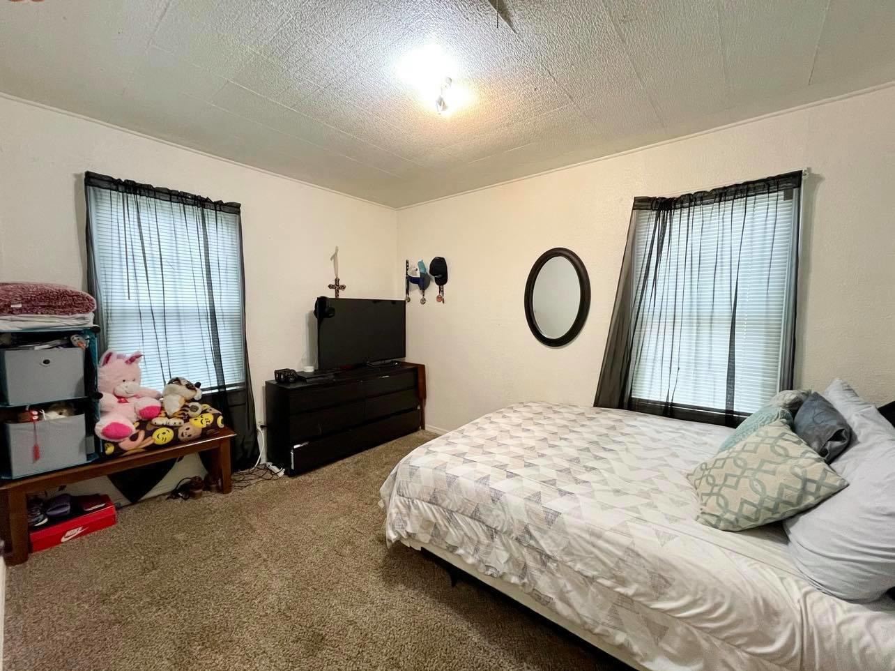 3812 South Hayden Street Amarillo, TX 79110 - Photo 7 of 9 a bedroom with a bed and a tv