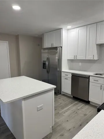 a kitchen with a sink stainless steel appliances and cabinets